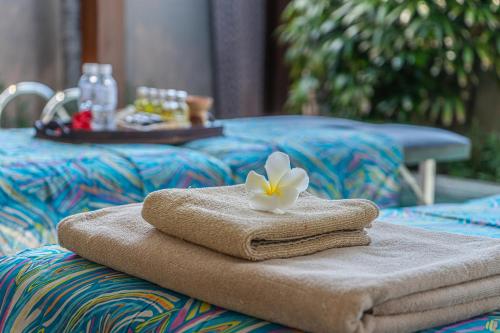 塞米亚克阿萨巴厘岛豪华别墅及Spa酒店的桌子上带花的毛巾