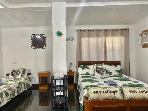 莫阿尔博阿Panagsama Holiday Cottage的一间卧室设有两张床和窗户。