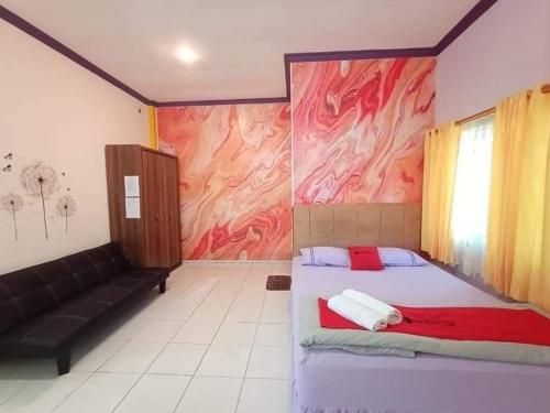 巴厘巴板Pavillion EMWEKA Balikpapan的一间卧室配有一张床和一张沙发