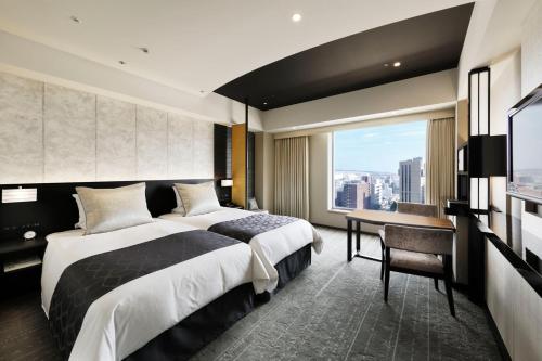 京都京都格兰比亚大酒店的一间卧室配有一张床、一张书桌和一个窗户。
