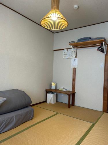 金泽白屋宾馆 的一间卧室配有一张床、一张书桌和一盏灯。