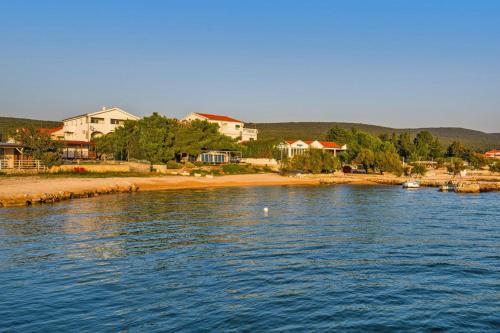 斯维蒂佩塔Apartment in Sveti Petar with balcony and seaview close to the beach的一片大片水,有房子和海滩