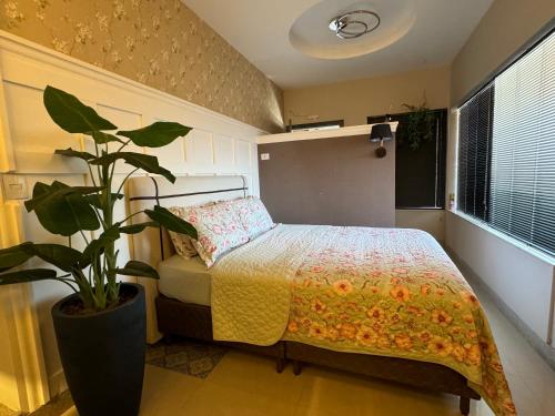 阿拉克鲁斯Hotel APART Zuccolotto 1的一间卧室配有一张床和盆栽植物