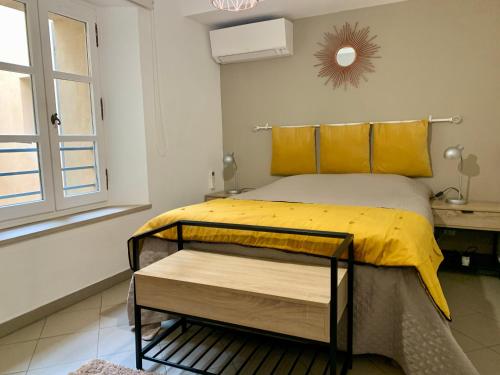 土伦Bel appartement 4 étoiles Centre Historique Toulon的一间卧室配有一张带黄色床单的床和一扇窗户。