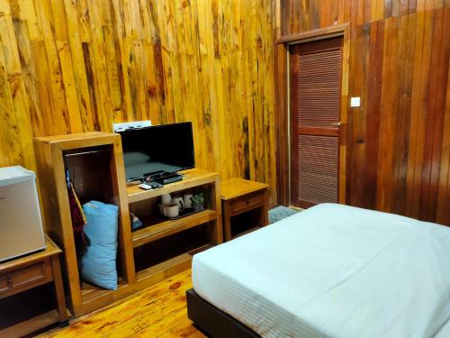士兆KEMBARA RESORT的一间卧室配有一张床和一台电视。