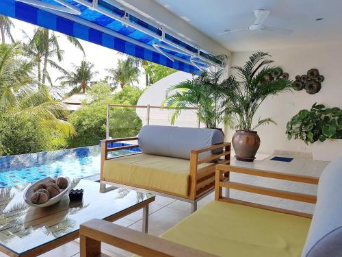 班邦宝Beachside 3-Bedroom Townhouse w Private Pool at 70 Meters from Beach的客厅配有沙发和桌子