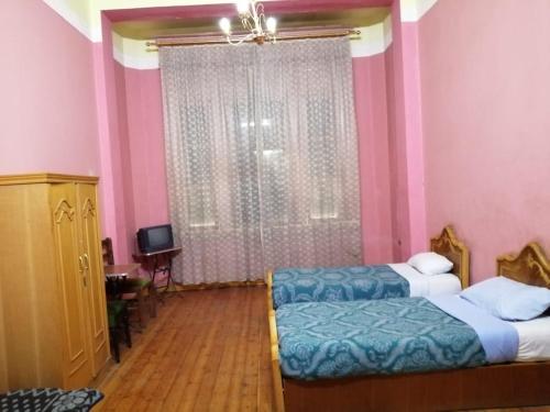 开罗柏林酒店 的一间卧室设有两张床,窗户拥有粉红色的墙壁。