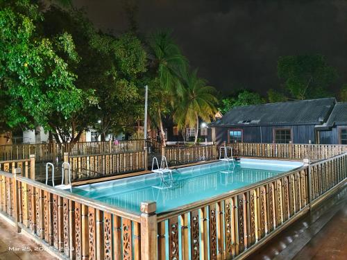 士兆KEMBARA RESORT的游泳池四周设有木栅栏