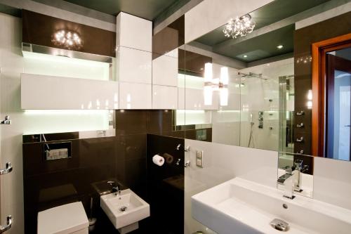 罗兹Młoda Europa的一间带水槽、卫生间和镜子的浴室