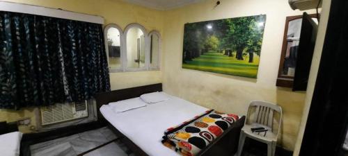 加尔各答Khaja Hotel的一间小卧室,配有床和窗户