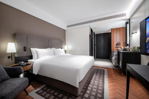 武汉武汉关山大道城际酒店的一间带白色大床的卧室和一间客厅