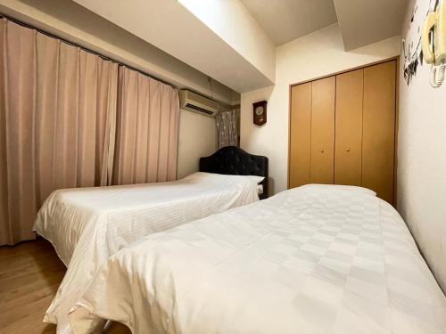 大阪A&C STAY Shinsaibashi的带两张床的小房间,带水电