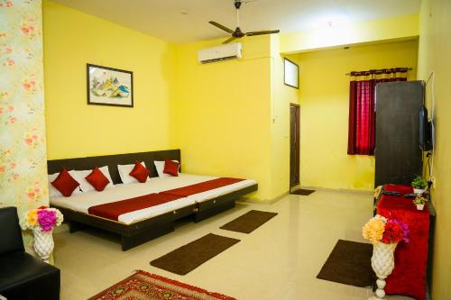KhandwaShubh Parisar的卧室配有一张床铺,位于一个黄色墙壁的房间