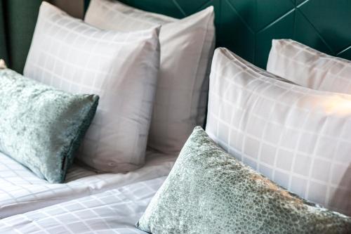 斯德哥尔摩Apartments By Ligula, Hammarby Sjöstad的一张带白色枕头和绿色白色枕头的床