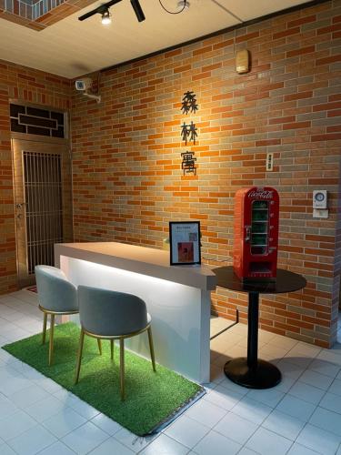 Minxiong森林寓的大堂设有红色电话亭和两把椅子