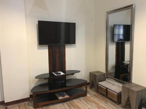 杜马格特查若斯多米特尔旅舍的一间配有电视和镜子的客房
