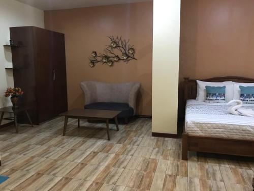 杜马格特查若斯多米特尔旅舍的一间卧室配有一张床、一把椅子和一张桌子