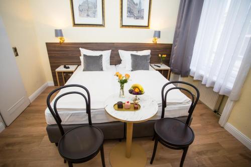 维也纳City Pension Stephansplatz I Self Check In的酒店客房配有一张带桌椅的床。
