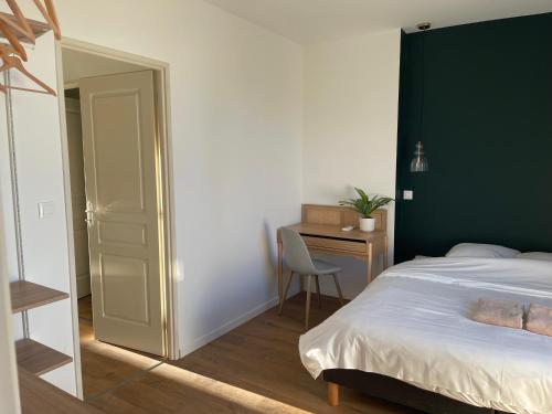 TonneinsAppart-Hôtel Résidence de Garonne的一间卧室配有一张带绿色床头板的床和一张书桌