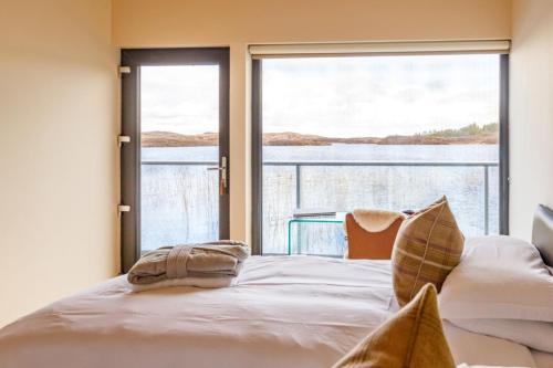 TomichThe Boathouse的一间卧室设有一张床和一个大窗户