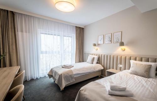 波兹南Apartamenty Wolności 6 self check-in 24h的酒店客房设有两张床和窗户。