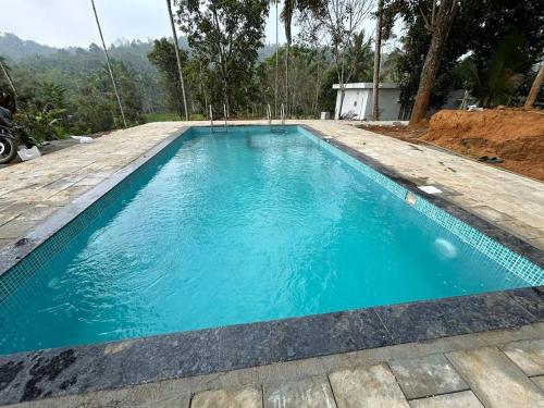 瓦亚纳德Silver Oak By Exuberance Stays (Independent Holiday Home)的蓝色房子中的游泳池