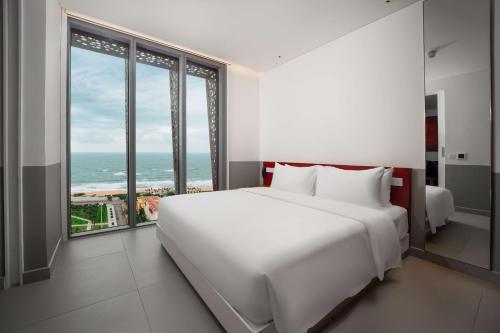 绥和市Wink Hotel Tuy Hoa Beach - 24hrs stay & Rooftop Pool Bar的卧室设有一张白色大床和大窗户