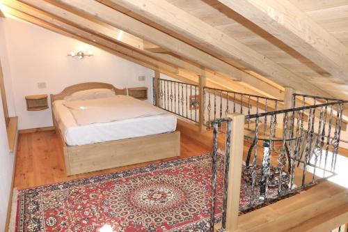 利维尼奥Appartamenti Bait Carosello的一间卧室配有一张床,楼梯铺有地毯。