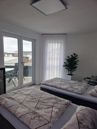 EngelsbrandFerienwohnung Alona的一间卧室设有两张床和一个带庭院的窗户。