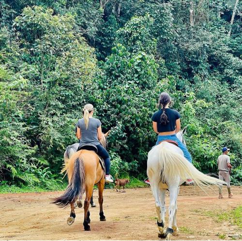 特雷索波利斯Pousada Jupter的两名妇女骑在土路上骑马