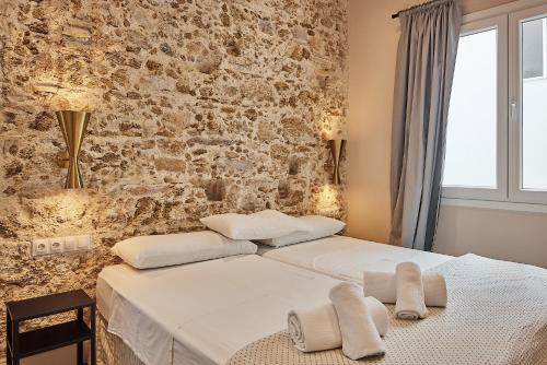 加的斯VG - Villa de Andas suites的一间卧室设有两张床和砖墙