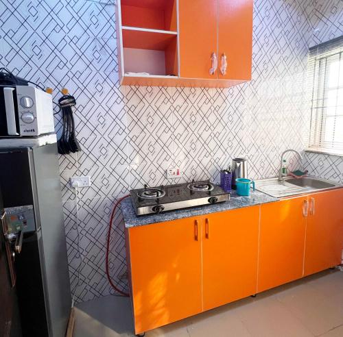 卡拉巴尔Signature Residence的橙色的厨房设有水槽和炉灶