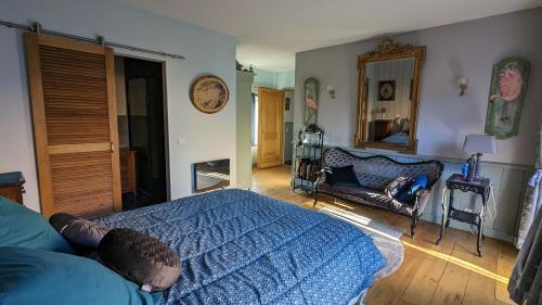 蓬格拉纳达蓝旅馆的一间卧室配有一张床、一张沙发和一面镜子