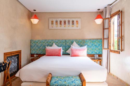 拉巴特里亚德卡拉的卧室配有带粉红色枕头的大型白色床