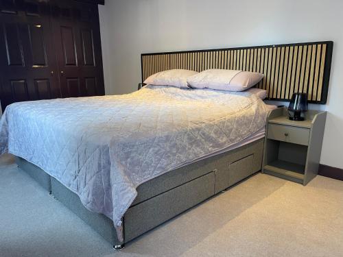 贝里圣埃德蒙兹Cathedral View Apartment, Flat 4的一间卧室配有一张带木制床头板的床