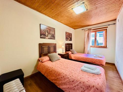 陶尔Apartamento Sant Climent Timmo的一间卧室设有两张床和木制天花板