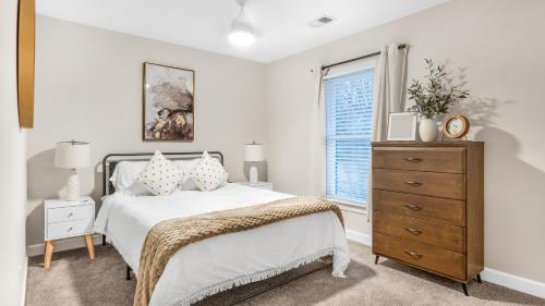 格林斯伯勒4-bedroom Bliss With Downtown Proximity的一间卧室配有一张床、一个梳妆台和一扇窗户。