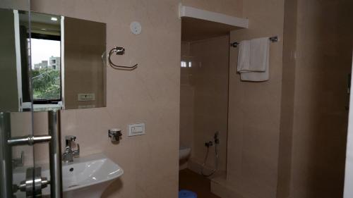 帕坦科特Hotel Park Street的浴室配有盥洗盆和带镜子的淋浴