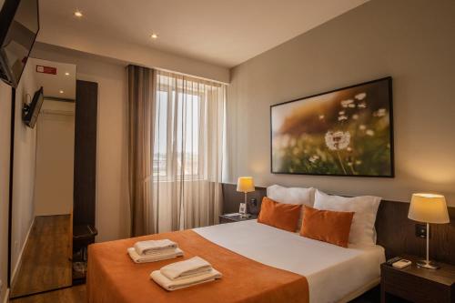 科英布拉河畔套房酒店的酒店客房,配有带两条毛巾的床