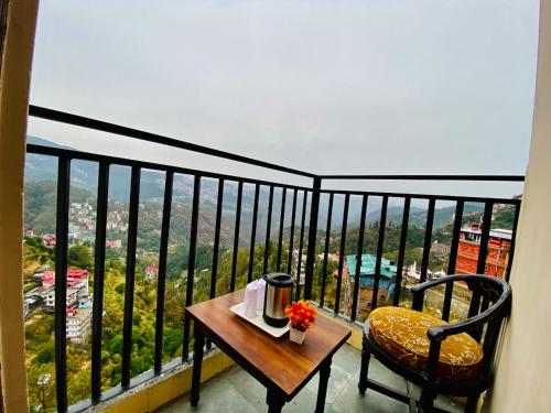 西姆拉Aachman velly view with terrace的美景阳台,配有桌椅