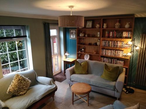 BlackfordbyThe Whimsy 2 bedroom cottage in National Forest, private parking & garden的客厅设有两张沙发和书架
