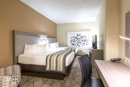 康科德夏洛特康科德米尔斯/高速公路温德姆集团温盖特酒店的配有一张床和一张书桌的酒店客房
