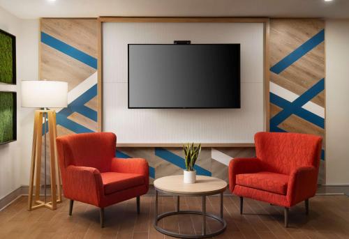伯灵顿波士顿伯灵顿希尔顿花园酒店的一间设有两把椅子和一台平面电视的等候室