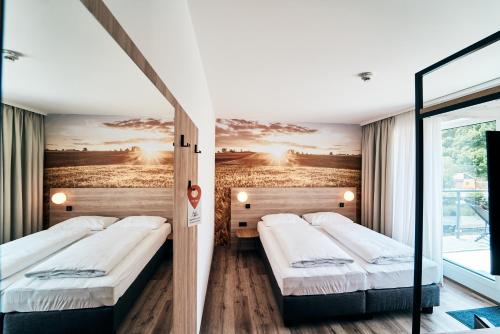 茨韦特尔I'M INN Zwettl - Hotel zum Brauhaus的墙上画画的房间里设有两张床