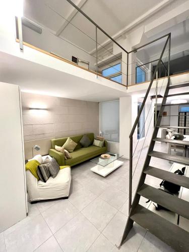 马德里Excelente loft en Trafalgar的客厅设有绿色沙发和楼梯。