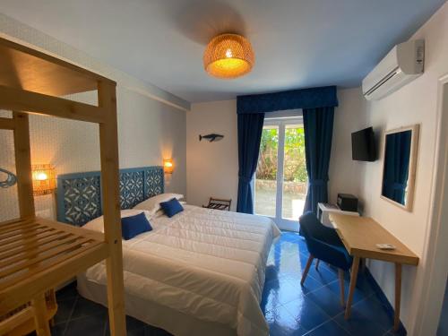 马萨鲁布朗斯Hotel Villa Lubrense Sorrento的一间卧室配有一张床、一张书桌和一个窗户。