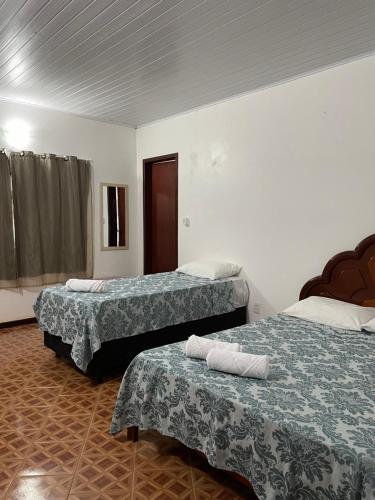 戈亚斯州上帕莱索Pousada Recanto dos Sonhos的酒店客房,配有两张带毛巾的床