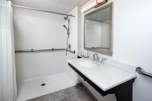 阿什维尔Country Inn & Suites by Radisson Asheville Downtown Tunnel Road的白色的浴室设有水槽和镜子