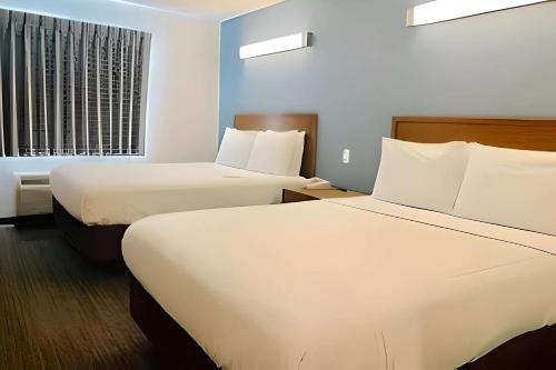 罗内特公园Inn at Rohnert Park的酒店客房设有两张床和窗户。