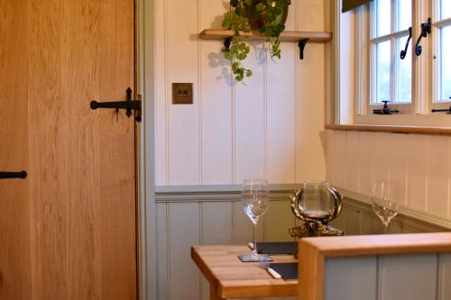 BurphamThe Deer Hut的厨房配有2个餐桌上的酒杯